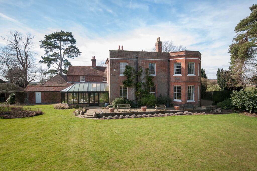 The Hermitage, a red-brick period country house with a conservatory and lawn near Tonbridge, Kent