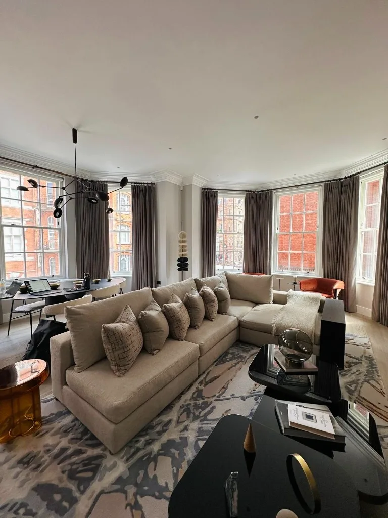 Reception room with an L-shaped sofa and bay windows on Mount Street, Mayfair