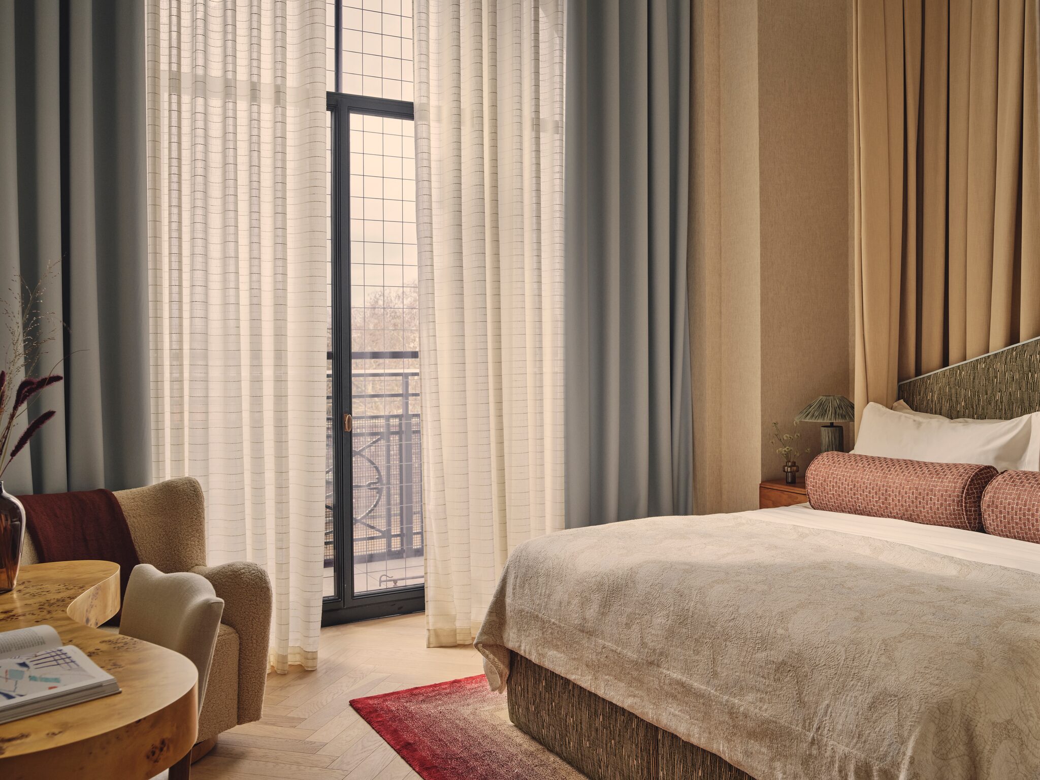Bedroom with armchair and full-height windows at The Whiteley, Queensway