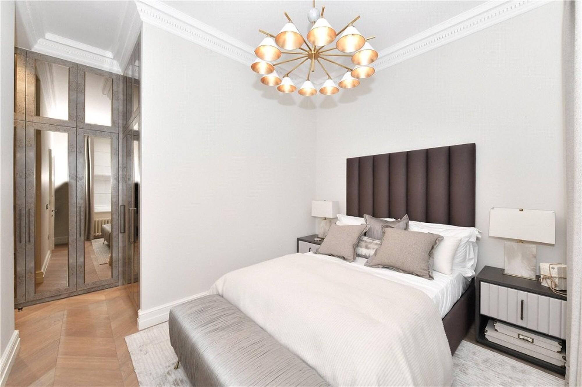 Second bedroom in the Mount Street apartment with mirrored wardrobe and tall headboard